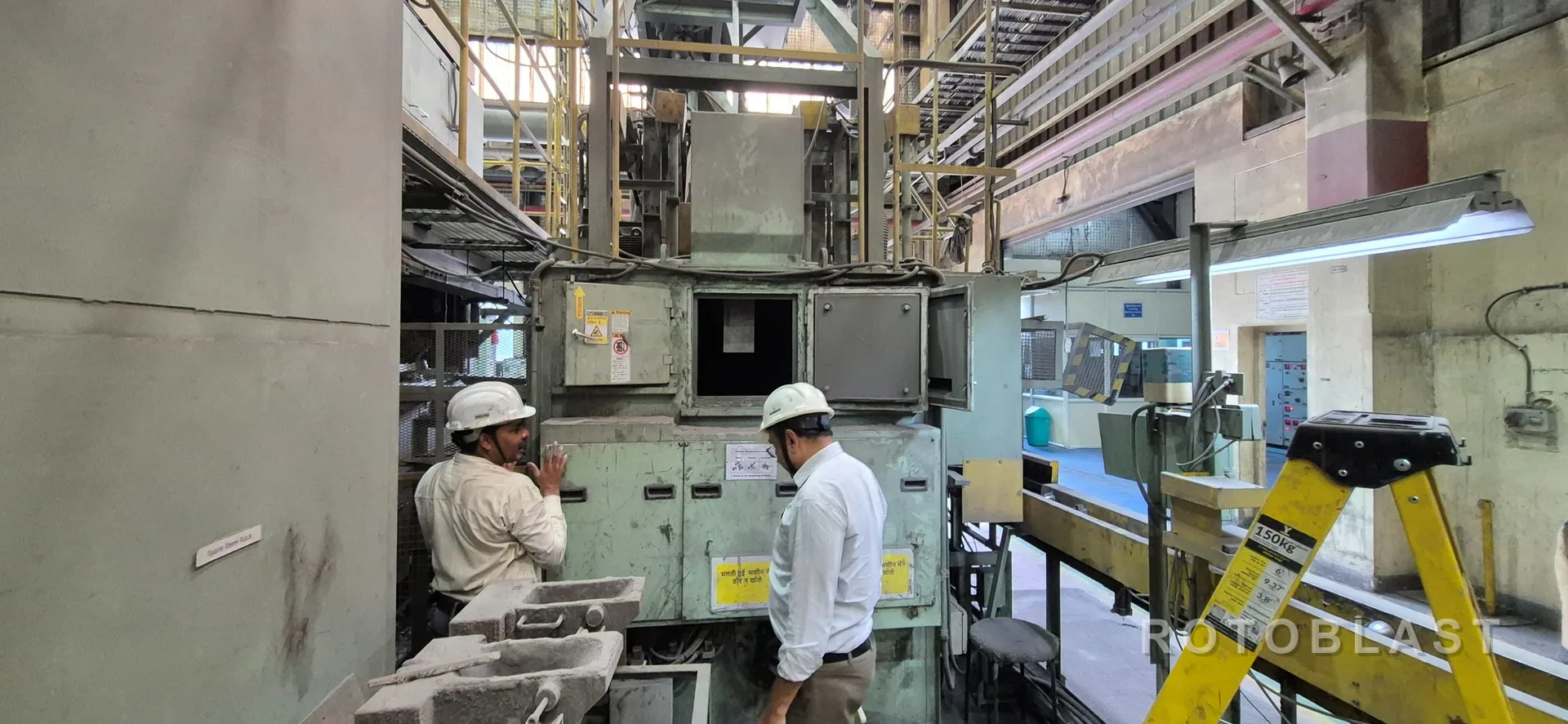 Rotoblast engineers inspecting a shot blasting machine on the shop floor during an AMC visit